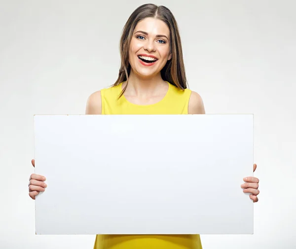 Vrouw met gele jurk teken boord houden. — Stockfoto