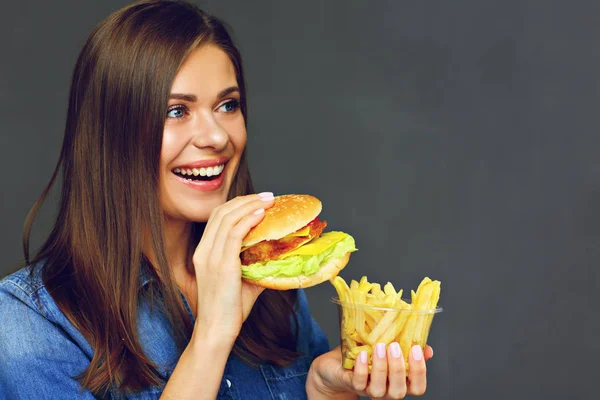 Χαμογελαστό γυναίκα κρατώντας burger με πατάτες πατάτες — Φωτογραφία Αρχείου