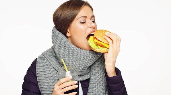 Jonge vrouw eten waardeloos hamburger met plezier. — Stockfoto