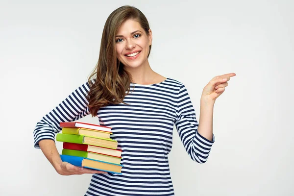 Student girl holding pile of books and pointig with finger — Stock Photo, Image