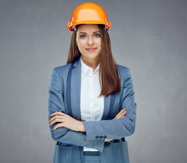 kadın Oluşturucusu mühendisi iş takım elbise gri duvar karşı çapraz kollar ile ayakta 