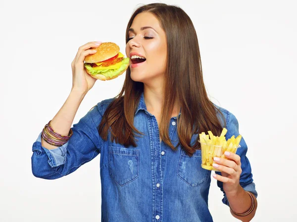 穿着蓝色牛仔裤 夹着汉堡和炸薯条的女孩 — 图库照片