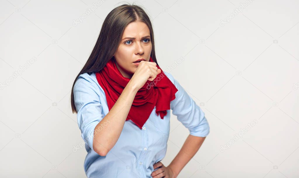 coughing sick woman in blue shirt and red scarf on gray wall background 