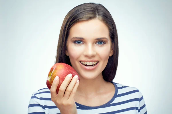 Mujer con frenillos sosteniendo manzana — Foto de Stock