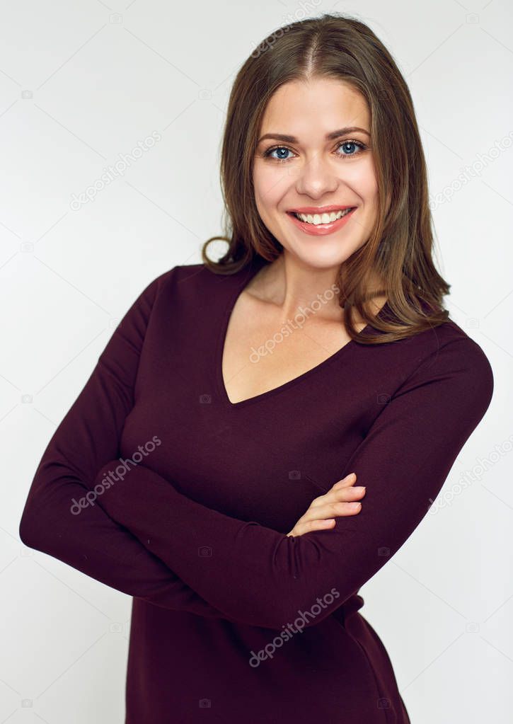 smiling woman wearing brown dress standing with crossed arms 