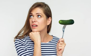 İzole salatalık çatal üzerinde tutan kadın portresi.