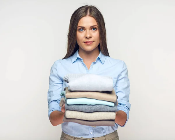 Smiling woman holding stack of warm winter clothes. — Stock Photo, Image