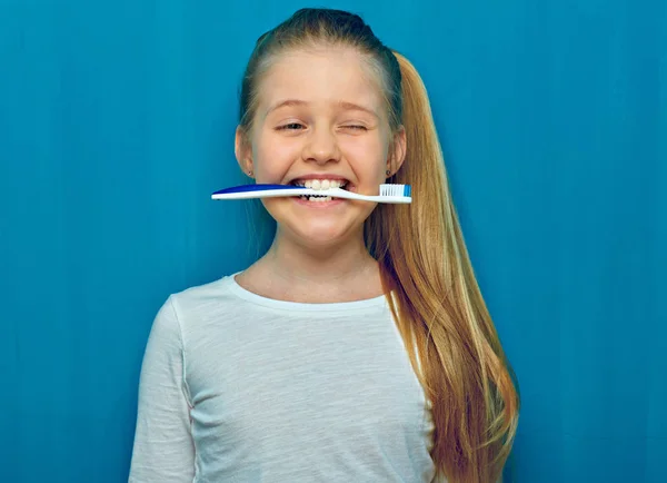 Menina Segurando Escova Dentes Com Dentes Fundo Parede Azul — Fotografia de Stock