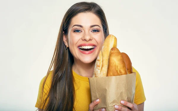 微笑的妇女拿着纸袋子与面包在轻的背景 — 图库照片