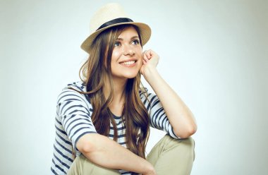 Çizgili kıyafetler ve hafif duvar arka plan oturan hipster şapka giyen kadın 
