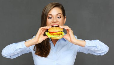 gri arka plan üzerinde lokanta kavramı hamburger yeme mutlu kadın portresi 