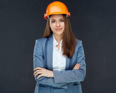 Siyah duvar arka planda gri takım elbise ve kask giyiyor gülümseyen kendine güvenen kadın mimar Oluşturucu