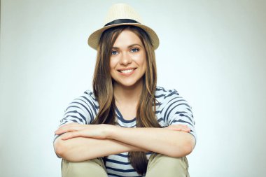 katlanmış elleriyle oturan hipster şapka giyen gülümseyen kadın portresi 