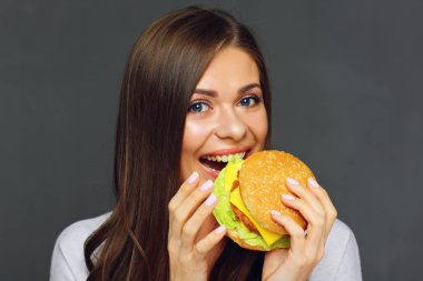 gri arka plan üzerinde lokanta kavramı hamburger yeme mutlu kadın portresi 