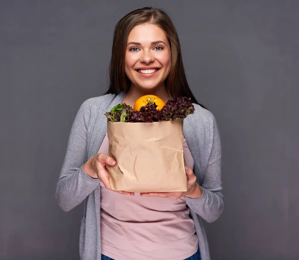 Женщина держит бумажный пакет с овощами — стоковое фото