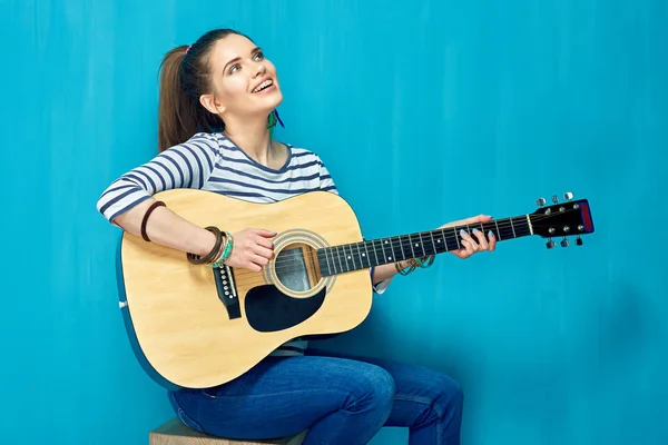 Mulher Atraente Tocando Guitarra Enquanto Sentado Perto Parede Azul — Fotografia de Stock