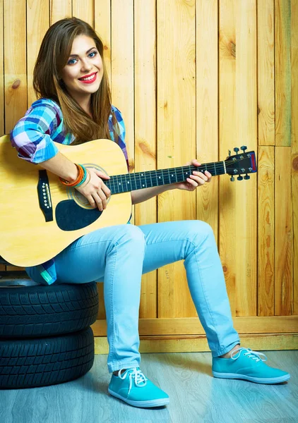坐在地板上的吉他和轮胎女人 — 图库照片