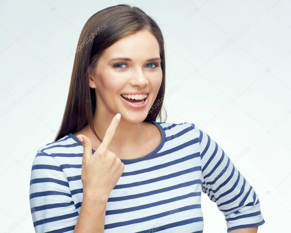 smiling woman pointing finger on dental braces and looking at camera 