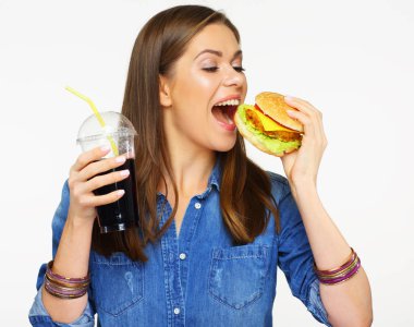 Mutlu kadın beyaz arka plan üzerinde izole cola cam ile burger tutan kot etek 