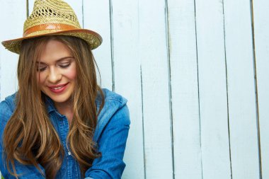 ahşap beyaz tahta arka plan üzerinde seyir şapkalı genç gülümseyen kadın