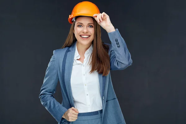 微笑自信的女建筑师建设者穿着灰色的西装和黑色的墙上的头盔背景 — 图库照片