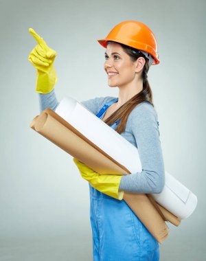 Planları tutarak ve gri arka plan üzerinde parmak işaret kadın builder mimar