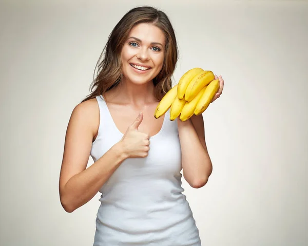 微笑的女人手里拿着黄色的香蕉 在米色的背景上显示出来的拇指 — 图库照片