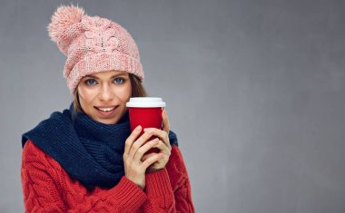 Gülümseyen kış şapka kırmızı c tutarak sıcak giysiler giyen kadın