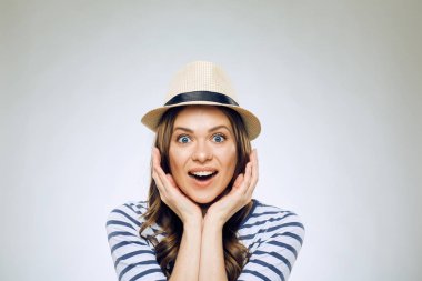 şapka ve çizgili gömlek gri arka plan üzerinde kameraya bakarak sürpriz kadın portresi