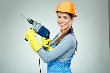 Giyen kadın Oluşturucusu gülümseyen korumak kask ve Matkap aracı tutan üniforma 