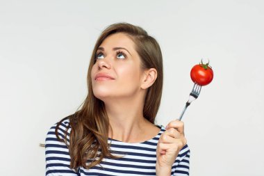 kavram diyet domates çatal üzerinde tutan genç kadın gülümseyerek