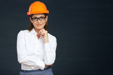 kask ve siyah arka plan üzerine poz gözlük gülümseyen genç kadın mimar