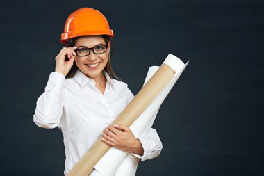 gülümseyen genç kadın mimar planları siyah arka planda tutan güvenlik kask