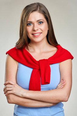 Çapraz kolları ile ayakta omuzları üzerinde kırmızı kazaklı mavi singlet gülümseyen kadın