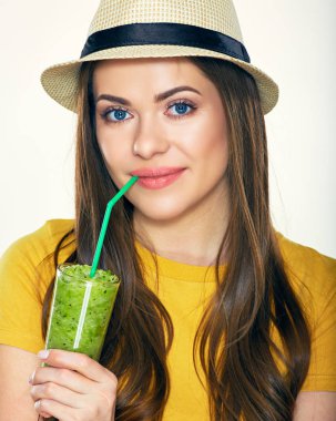 Yeşil smoothie suyu içme şapkalı genç kadın