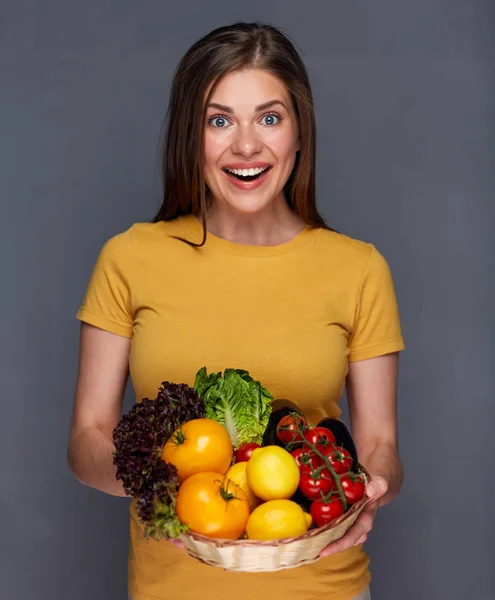 笑顔の女性は 灰色の背景に夏野菜のバスケットを持ってクローズ アップ — ストック写真