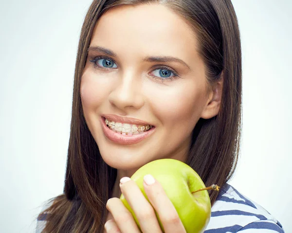 带牙套的微笑的妇女拿着绿色苹果 — 图库照片