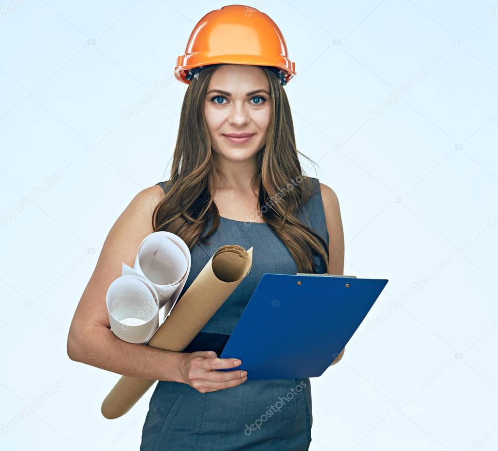 smiling young woman architect in safety helmet holding blueprints