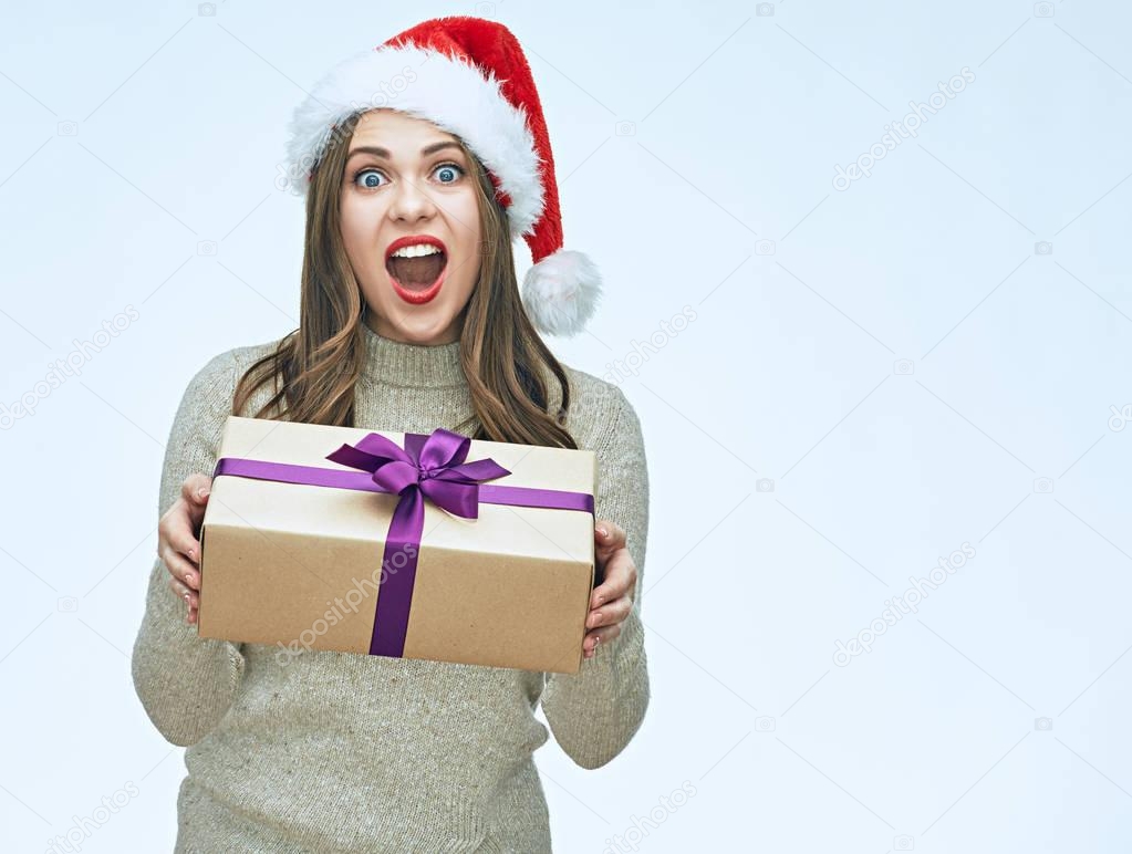 Beautiful surprised woman in santa hat holding gift box, new year concept