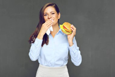 lokanta burger tutarak ve kağıt peçete kullanarak genç çekici kadın portresi 