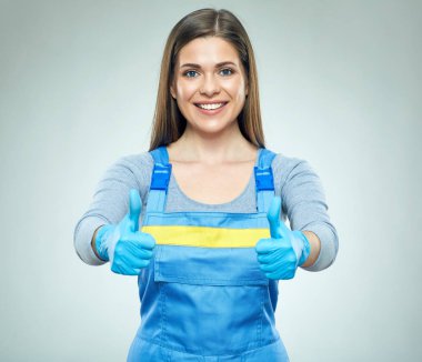 başparmak temiz işçi üniforma giyen gülümseyen kadın gösterilmesini 