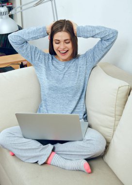 kanepede oturan ve evde laptop ile çalışan kadın 