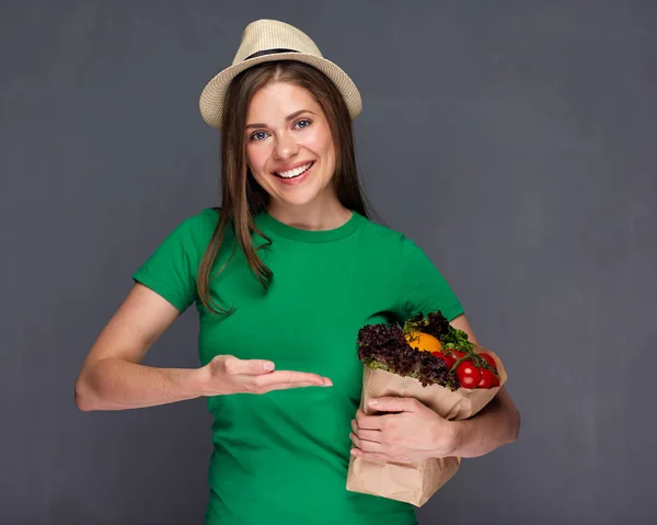 バイオ食品紙袋を押しながらそれを手で指している現代の女性 — ストック写真