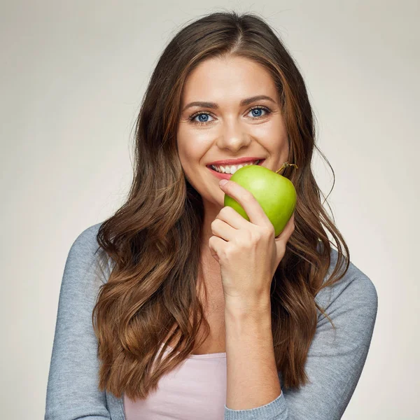 Lächelnde Frau beißt in grünen Apfel. — Stockfoto