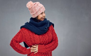 örme kazak ve kış eşarp gri arka plan üzerinde poz giyen güzel gülümseyen kadın 