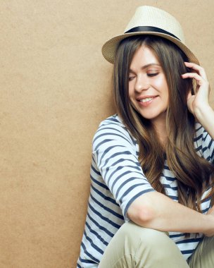 hipster şapka ışık arka plan üzerinde gülümseyen genç kadın