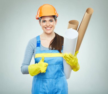 Planları tutarak ve başparmak gösterilmesini gülümseyen kadın mimar 