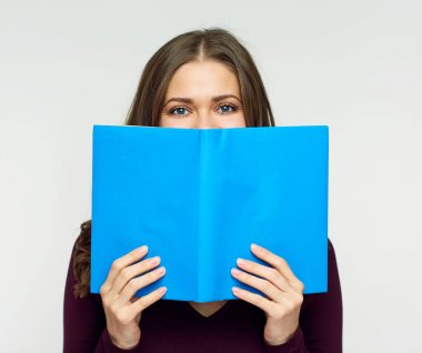 Öğrenci kadın mavi kitap arkasında yüz gizleme