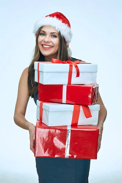 美丽的微笑的妇女穿着圣诞圣诞老人帽子举行礼物堆 — 图库照片