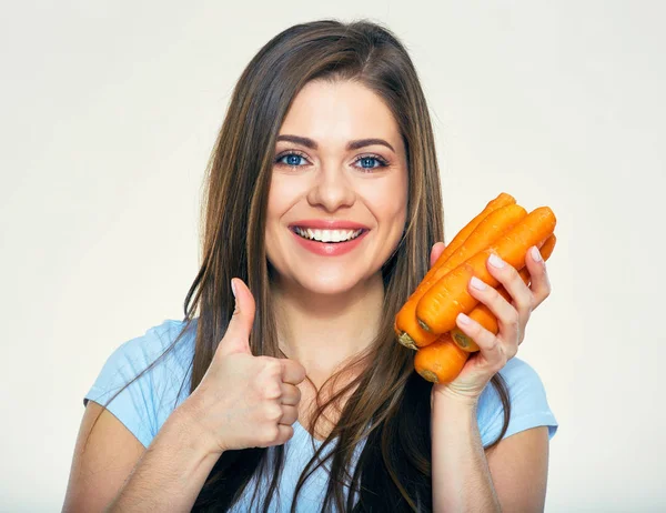 Mujer sonriente sosteniendo zanahoria dando el pulgar hacia arriba —  Fotos de Stock